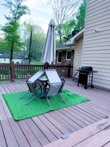 a patio with a table and an umbrella on a deck at Comfort Cove Snellville in Snellville