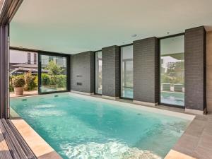 a swimming pool in a house with windows at Zilte Watervilla in Kamperland