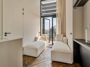 a living room with white chairs and a window at Zilte Watervilla in Kamperland
