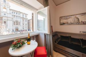 un tavolo con una bottiglia di vino e una finestra di Rhea Silvia Luxury Navona a Roma