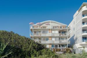 a tall white building with trees in front of it at Seacrest 9 in Gold Coast