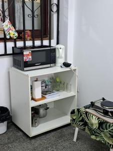 a white shelf with a microwave on top of it at Tia Clara in San Salvador de Jujuy
