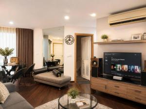 a living room with a tv and a couch and a table at The Greenway Sukhumvit 50 in Phra Khanong