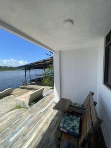 a room with a bench and a view of the water at Hotel Pura Natura Riverside Tortuguero in Tortuguero