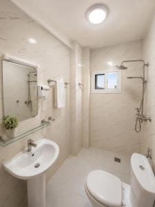 a white bathroom with a sink and a toilet at Modern Central Studio - Dakar Plateau in Dakar