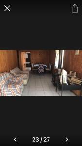 a living room with two beds and a table at MamiKiki Pangui2 in Panguipulli