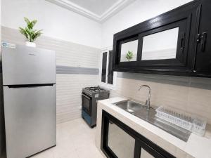 a kitchen with a white refrigerator and a sink at Modern Central Studio - Dakar Plateau in Dakar