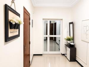 a hallway with white walls and a door with potted plants at Modern Central Studio - Dakar Plateau in Dakar +4 photos