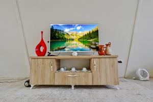 a tv on a wooden stand with a television on it at Villa Olivia in Elbasan