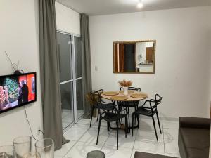 a dining room with a table and chairs and a mirror at Ap com 2 quartos climatizados , com fechadura eletrônica, WI-FI ,condomínio Village do bosque 3 in Imperatriz