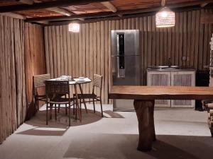a kitchen with a table and chairs and a refrigerator at Casa Irmã Lua in Porto Seguro