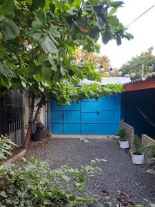 a blue garage door in front of a house at Hostal Niña Oly in El Sunzal