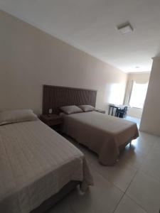 a bedroom with two beds and a window at Pousada Posto Junior - Madalena CE in Madalena