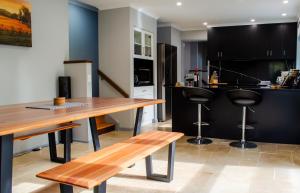 a kitchen with a wooden table and two bar stools at Koblenz Haus - “Heart of the Barossa” - (New Mgmt) in Tanunda +15 photos