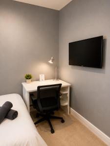 a bedroom with a desk with a computer and a tv at Catherines House Kings Cross Area in London