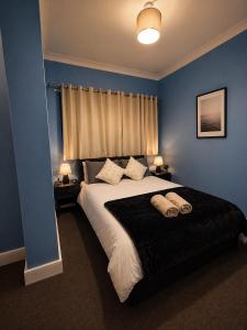 a bedroom with a large bed with blue walls at Catherines House Kings Cross Area in London