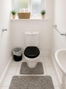 a bathroom with a toilet with a black seat at Catherines House Kings Cross Area in London