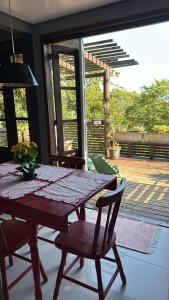 a wooden table and chairs in a room with a patio at Chalé cercado pela natureza in Imbituba