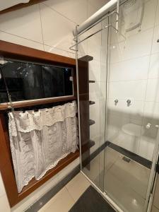 a bathroom with a shower and a glass shower stall at Chalé cercado pela natureza in Imbituba +4 photos