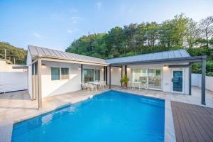 a house with a swimming pool in front of a house at Yangyang Sonamu Private Pension in Yangyang