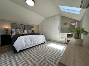 a bedroom with a large bed and a skylight at Meerendahl Luxury Apartments at Heritage Square in Durbanville