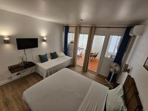 a hotel room with a bed and a balcony at COZY Studio 331 ADR in Saint-François