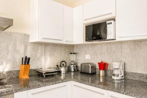 a kitchen with white cabinets and a microwave at Private Iberosta Villa Lagoon 4BDR- Private Beach and Pool in Punta Cana