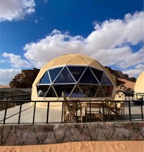 a yurt in the desert with tables and chairs at The bubble camp in Wadi Rum