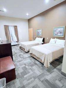 a hotel room with two beds and two windows at COLLINS INN & SUITES in Collins +15 photos