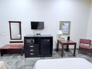 a hotel room with a bed and a tv at COLLINS INN & SUITES in Collins