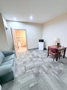 a living room with a couch and a desk and a table at COLLINS INN & SUITES in Collins