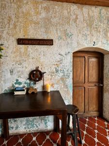 a wooden table and a cabinet in a room at Amura Hostel - Antigua Guatemala in Antigua Guatemala
