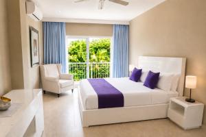 a bedroom with a bed and a chair and a window at Private Iberosta Villa Lagoon 4BDR- Private Beach and Pool in Punta Cana