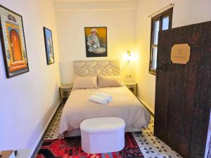 a small bedroom with a bed and a stool at Riad Boutique Baba in Rabat