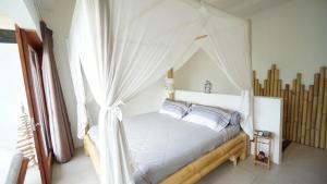 a bedroom with a white bed with a canopy at Villa Fireflies in Darmasaba +19 photos