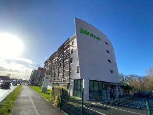 a building with a sign on the side of it at ibis Styles Rennes Cesson in Cesson-Sévigné