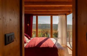 a bedroom with a bed and a large window at Ámpelos Wine Room in Gallo +1 photo