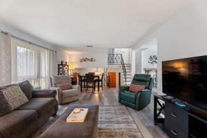 a living room with a couch and a tv at Arden Place - Spacious Retreat with Pool in High Point