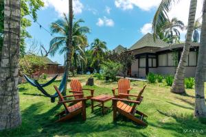 a group of chairs and a hammock in front of a house at Ecohotel Raices del Rosario in Cartagena de Indias