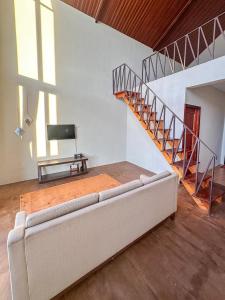a living room with a couch and a staircase at Zambrud Villa Dieng in Kejajar