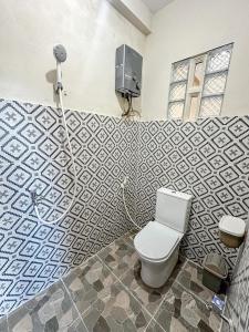 a bathroom with a toilet and a wall at Zambrud Villa Dieng in Kejajar +6 photos