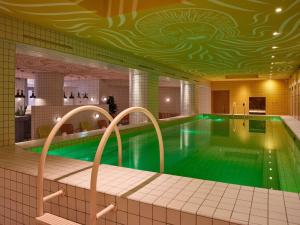 a swimming pool in a hotel with a green pool at Mama Shelter Roma in Rome +236 photos