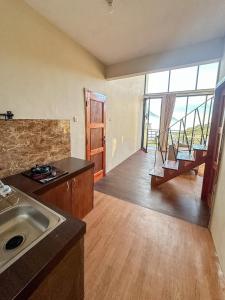a kitchen with a sink and a large window at Zambrud Villa Dieng in Kejajar