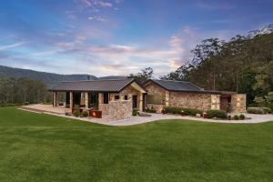 a stone house with a green lawn at Villa Arbosana in Barrengarry