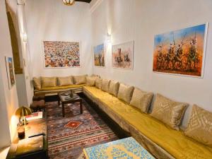 a large couch in a living room with paintings on the wall at Riad Boutique Baba in Rabat