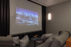 a living room with a couch and a projection screen at UNIT Nuanu Village in Canggu