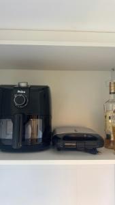 a black toaster and a toaster on a shelf at Vila confort in Vila Velha