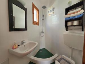 a bathroom with a sink and a toilet and a mirror at Agla Studio 2 in Fournoi +37 photos