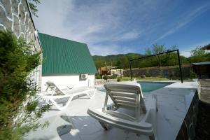 two lounge chairs and a swimming pool with a green roof at Ismayilli in İsmayıllı