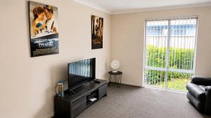 a living room with a flat screen tv and a couch at Napolean Holiday Retreat in Vasse